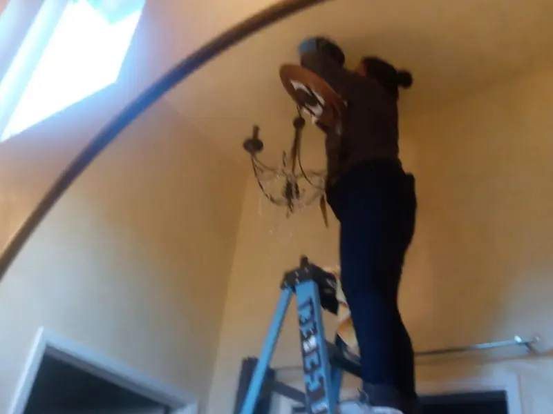 Electrician installing a chandelier in a Defiance residence